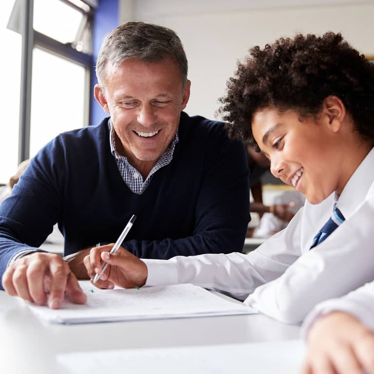 Teacher and student working together at a desk