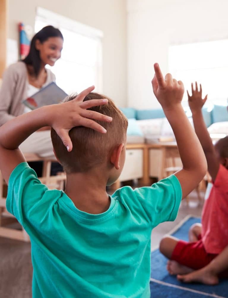 Students raising their hands during a classroom lesson